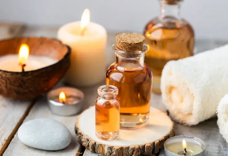 Aromatherapy massage oils and burning candle symbolizing warmth and comfort during massage.